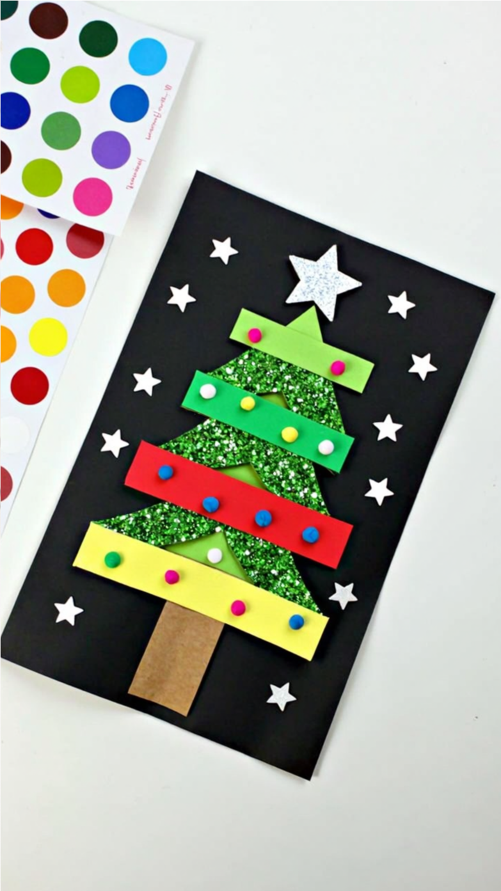Handmade Christmas card featuring a glittery green Christmas tree decorated with colorful foam strips, pom-poms, and a silver star, set on a black background with white star decorations